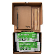 Open box showing kit contents: two blocks of air dry clay, three wooden tools and an a5 sketchbook.